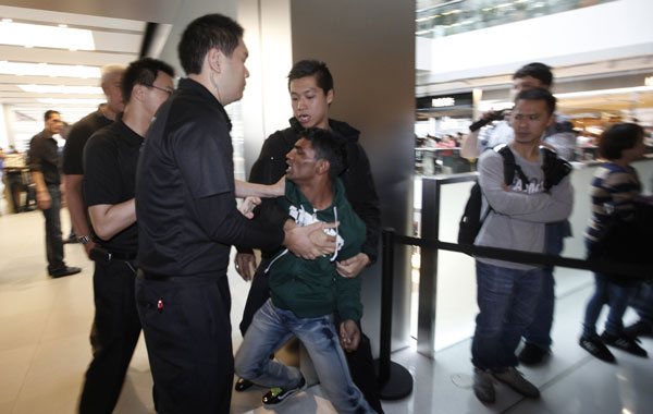 A man scuffles with security guards as he wants to buy new iPhone 4S outside a Apple Store in Hong Kong Friday, Nov. 11, 2011. Apple began selling new iPhone 4S in Hong Kong on Friday (AP)