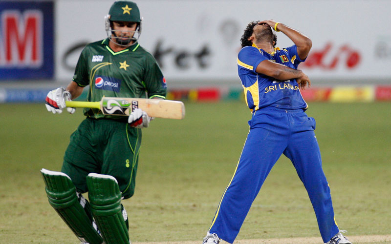 Sri Lanka's Lasith Malinga (R) reacts as Pakistan's Saeed Ajmal takes a run during the second one day international cricket match in Dubai. (REUTERS)