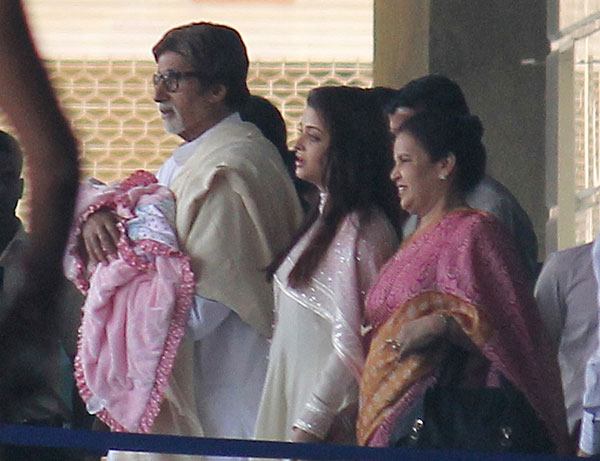 Amitabh Bachhan holds his granddaughter walking with Aishwarya Rai Bachhan as they leave the seven hills hospital in Mumbai on November 22, 2011 (AFP)