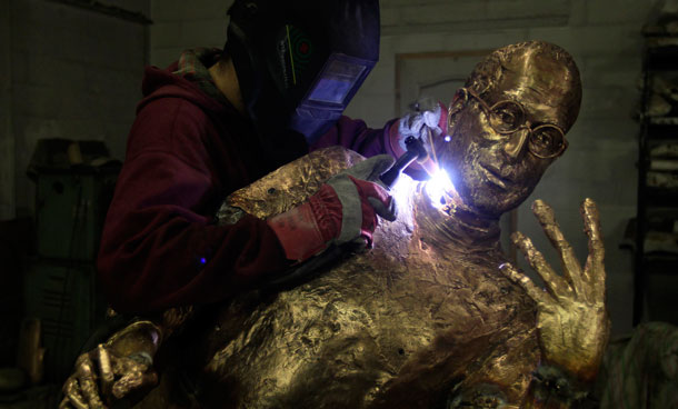 An assistant of Hungarian sculptor Erno Toth makes adjustments to his latest work, a bronze statue of late Apple co-founder Steve Jobs, in Budapest December 6, 2011. The statue was commissioned by chief of Hungarian software maker Graphisoft Gabor Bojar and will be delivered on December 20. (REUTERS)