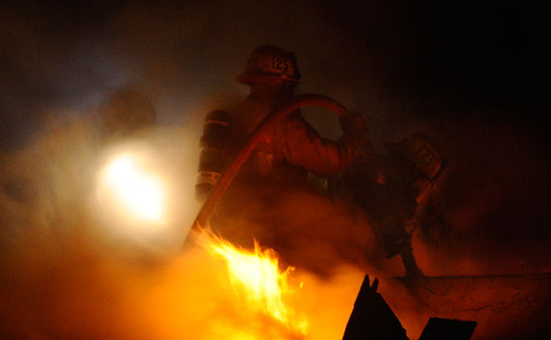 Firefighters battle a three-alarm apartment fire that started in the carport and spread into nearby units late Saturday night in Glendale, California. Firefighters in Los Angeles were steeling themselves for a busy New Year's eve on Saturday, following a rash of arson fires that saw more than 30 cars torched in recent days. (REUTERS)