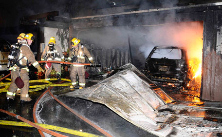Firefighters battle a three-alarm apartment fire that started in the carport and spread into nearby units late Saturday night in Glendale, California. Firefighters in Los Angeles were steeling themselves for a busy New Year's eve on Saturday, following a rash of arson fires that saw more than 30 cars torched in recent days. (REUTERS)