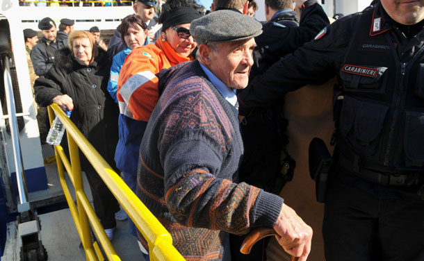 Crowds prepare to leave the island of Giglio, where passengers aboard the cruise ship Costa Concordia have been staying after the vessel ran aground, on January 14, 2012 in Giglio Porto, Italy. More than four thousand people were on board when the ship hit a sandbank. At least 3 people have been confirmed dead and another 50 are unaccounted for. (GETTY)