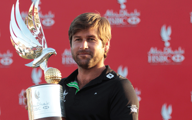 Robert Rock of England poses with the trophy after winning the Abu Dhabi Championship at the Abu Dhabi Golf Club. Rock won his head-to-head duel with a ragged Tiger Woods to lift the Abu Dhabi Championship title on Sunday after the former world number one produced his worst performance of the week. (REUTERS)