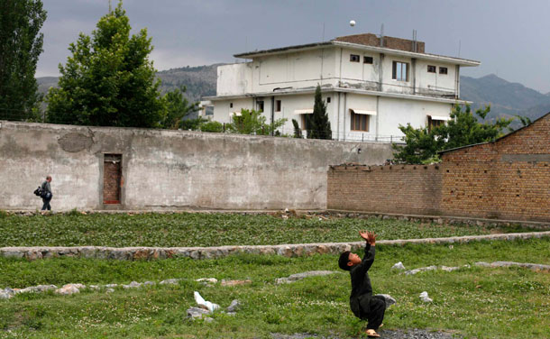 A boy plays with a tennis ball in front of the compound where U.S. Navy SEAL commandos killed al Qaeda leader Osama bin Laden. Pakistani security forces on began demolishing the house where bin Laden was killed by US special forces in Abbottabad last May a senior police official in the town said. (REUTERS)