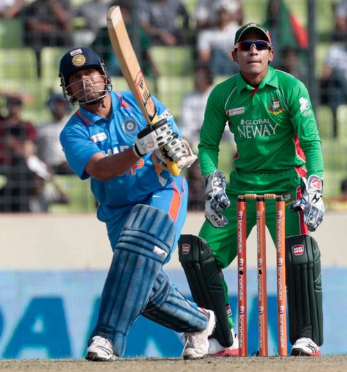 India's Sachin Tendulkar plays a shot as Bangladesh's captain Mushfiqur Rahim watches during their One Day International (ODI) cricket match of Asia Cup in Dhaka March 16, 2012 (REUTERS)