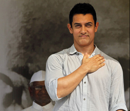 Aamir Khan gestures as anti-corruption activist Anna Hazare, back, looks on during the 12th day of Hazare's fast against corruption in New Delhi. (AP)