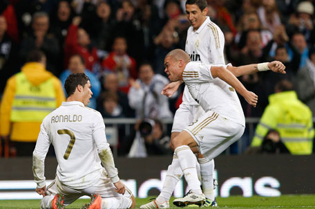 Real Madrid's Cristiano Ronaldo (left) celebrates after scoring a goal against Sporting Gijon with teammates Pepe and Angel Di Maria during their Spanish First Division match at Santiago Bernabeu stadium in Madrid on Saturday. (REUTERS)