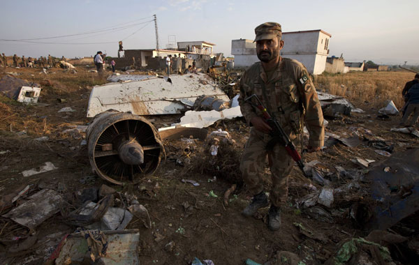 A paramilitary soldier walks past the wreckage of a Boeing 737 airliner that crashed in Islamabad April 21, 2012. The Pakistani airliner, with 127 people on board, crashed in bad weather as it came in to land in Islamabad on Friday, scattering wreckage and leaving no sign of survivors. The Boeing 737, operated by local airline Bhoja Air, was flying to the capital from Pakistan's biggest city and business hub Karachi.  (REUTERS)