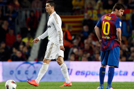 Real Madrid's Cristiano Ronaldo (left) walks past Barcelona's Lionel Messi after scoring his goal during their Spanish first division 'El Clasico' match at Nou Camp stadium in Barcelona on Saturday. (REUTERS)