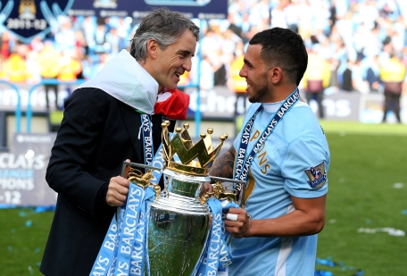 Manchester City manager Roberto Mancini and Carlos Tevez celebrate with the trophy following the Barclays Premier League match against Queens Park Rangers at the Etihad Stadium on Sunday in Manchester, England. (GETTY)