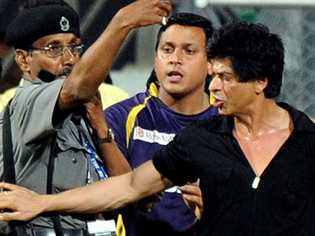 Bollywood actor and IPL franchise Kolkata Knight Riders co-owner Shah Rukh Khan brushes aside a security guard blowing a whistle to direct children accompanying him off the playing field at The Wankhede Stadium in Mumbai. (AFP)