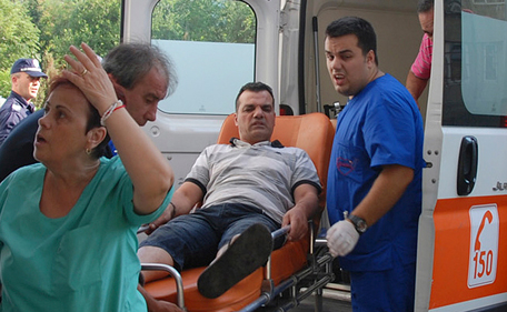 Unidentified Israeli tourist is helped as she arrives to Bourgas hospital after a bus carrying Israeli tourists in the Bulgarian resort city of Bourgas exploded Wednesday, July 18, 2012, killing at least three people and wounding more than 20 others, police said. (AP)