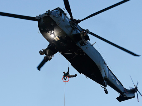 Royal Marine Martyn Williams carries the London 2012 Olympic torch as he abseils from a helicopter at the Tower of London July 20, 2012.  (REUTERS)