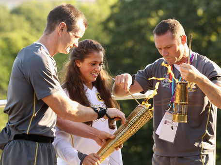 Natasha Sinha (C), 15, holds the Olympic torch as it is lit at the Observatory in Greenwich Park on July 21, 2012 in London, England. The 64th day of the Olympic torch relay will see torchbearers carry the flame through the capital for the first full day in London ahead of the 2012 Olympic Games. (GETTY)