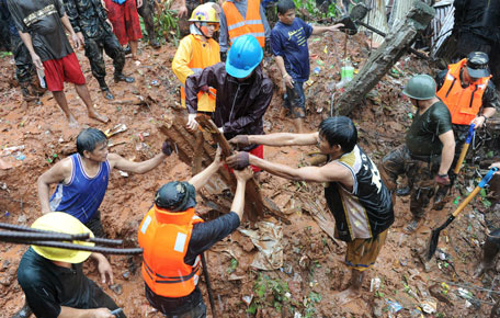 Rescuers dig through the rubble of a landslide to try to rescue people buried after a landslide hit Quezon City in suburban Manila caused by torrential rains. At least five people were killed and seven were missing as torrential rains brought the Philippine capital to a standstill, with floodwaters covering half the sprawling city, officials said. (AFP)