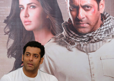 Bollywood actor Salman Khan smiles as he stands in front of a poster showing himself and actress Katrina Kaif at a press conference to promote the film 'Ek Tha Tiger' or 'Once There was a Tiger'. (AFP)