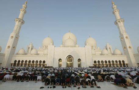 People greet praying at the start of  Eid'l Ftir at the Zayed Grand Mosque in Abu Dhabi. Photo by Erik Arazas