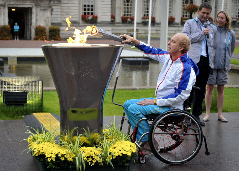 Double gold-winning cyclist Simon Richardson lights the cauldron with the Welsh Flame at a ceremony for the London 2012 Paralympic Games torch relay outside Cardiff City Hall in Wales. The Paralympics start with the opening ceremony on August 29.  (AFP)