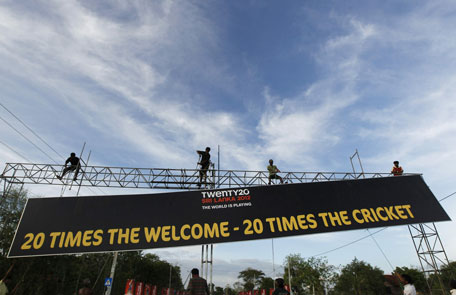 Workers hang an advertising board for the International Cricket Council's (ICC) Twenty20 World Cup cricket series in Hambantota. (REUTERS)