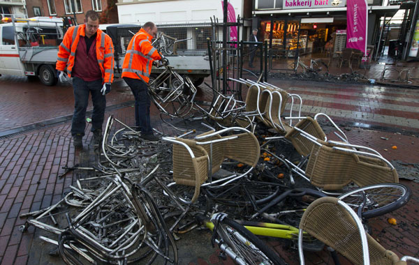 Workers clean up debris in a street in the northern dutch town of Haren, on September 22, 2012, a day after riot police went into action to contain thousands of party-goers who turned up after a teenager's birthday invite on Facebook went viral. Dutch news agency ANP quoted a correspondent as saying the situation in Haren was getting out of control as police were pelted with stones, bottles, bicycles and pots of flowers by angry youths. The police had been on high alert after the schoolgirl posted a message inviting friends to her 16th birthday party, but forgot to mark it as a private event, prompting more than 20,000 replies.
(AFP)