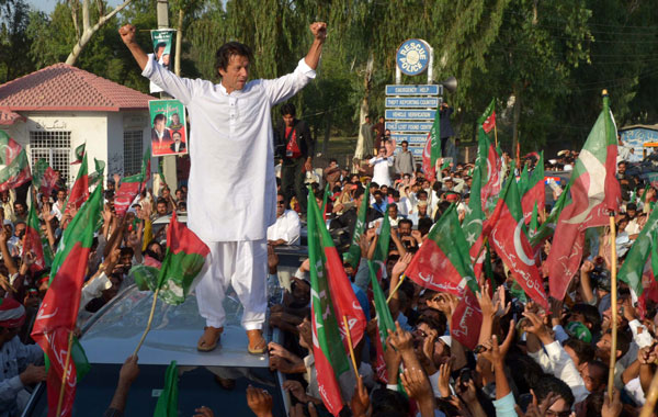 Pakistan cricket star turned politician Imran Khan (C) gestures as he stands on a vehicle during a rally in Mianwali, northern Pakistan, on October 6, 2012. Pakistani cricketer turned politician Imran Khan led Western activists and thousands of supporters on a defiant march to the tribal belt to protest against US drone strikes. Crowds lined the road to greet Khan, and scrums of media and well-wishers thronged his 4X4 as the convoy of more than 100 vehicles embarked on the 440-kilometre (270-mile) drive from Islamabad to South Waziristan.  (AFP)