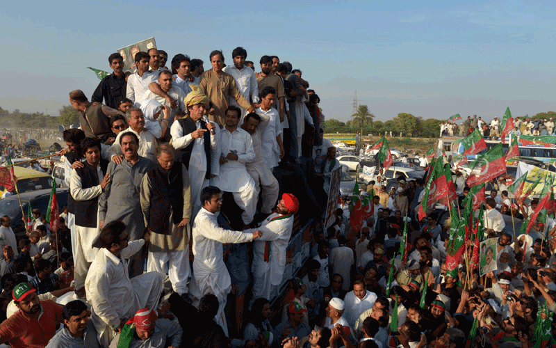 Leaders of Pakistan Tehreek-e-Insaaf (PTI) or Movement for Justice party watch Imran Khan (C) as he addresses supporters in Tank, the last town before the semi-autonomous area. Cricketer turned politician Imran Khan and his followers were stopped from entering Pakistan's tribal region after they bypassed road blocks to press towards the region to protest against US drone strikes. (AFP)