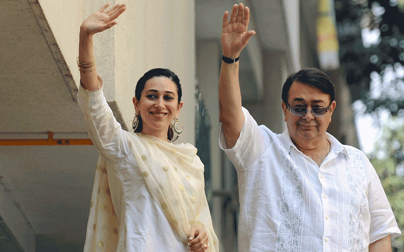 Randhir Kapoor (R), father of newly-wedded Bollywood actress Kareena Kapoor, and Kareena's sister Karishma Kapoor, wave towards media outside Saif Ali Khan's residence in Mumbai (AFP)