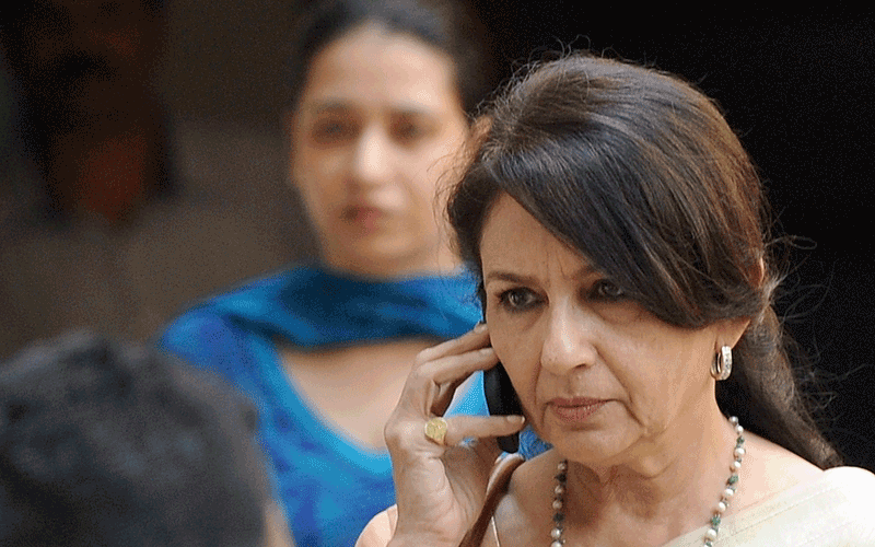 Sharmila Tagore, mother of newly-wedded Bollywood actor Saif Ali Khan, speaks on her mobile phone as she leaves her son's residence in Mumbai (AFP)