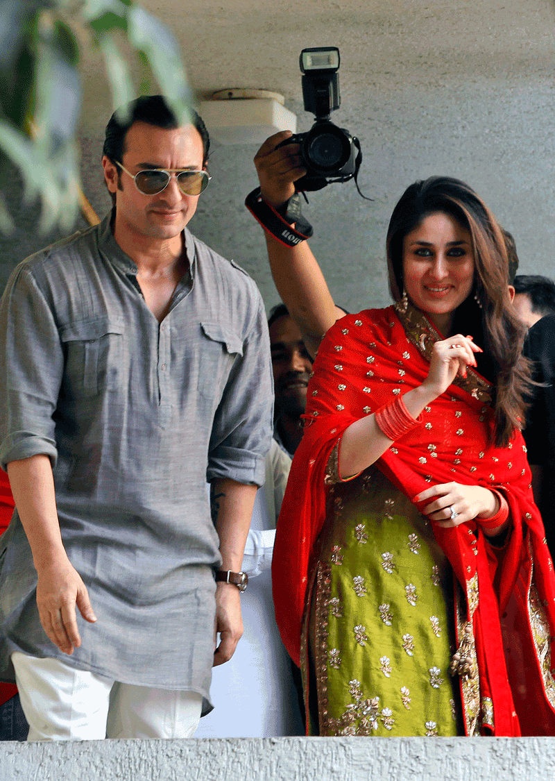 Bollywood stars Saif Ali Khan, left, and Kareena Kapoor step out on a balcony to greet waiting fans after getting married in Mumbai, India (AP)