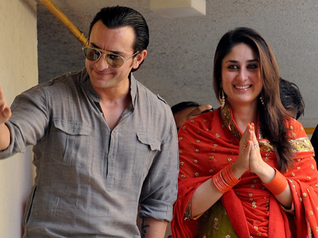 Newly-wedded Bollywood personalities Saif Ali Khan (L) and Kareena Kapoor gesture as they pose for the media outside Khan's residence in Mumbai on October 16, 2012. (AFP)