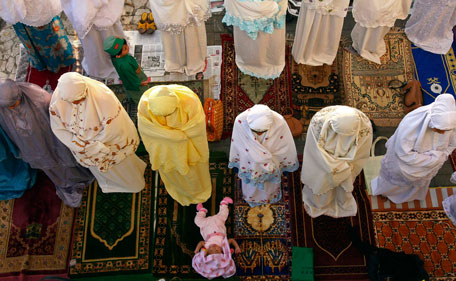 A baby girl lies on the floor as her mother prays to mark the Muslim sacrifice day of Eid al-Adha in Makassar in Indonesia's South Sulawesi province October 26, 2012. Indonesia, the world's most populous Muslim nation, celebrates Eid al-Adha by slaughtering goats and cows and distributing the meat to the poor. (REUTERS)