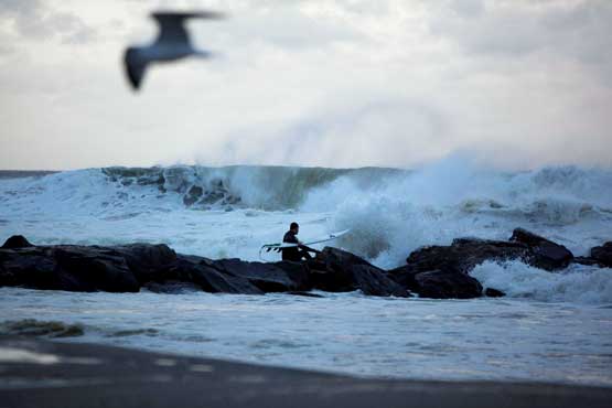 A man surfs at Rockaway Beach as Hurricane Sandy approaches on October 28, 2012 in Queens, New York. As some residents of New York and the area make preparations for bad weather, Sandy is heading up the East Coast and will make a possible first landfall near the Delaware coast (Getty Images/AFP)