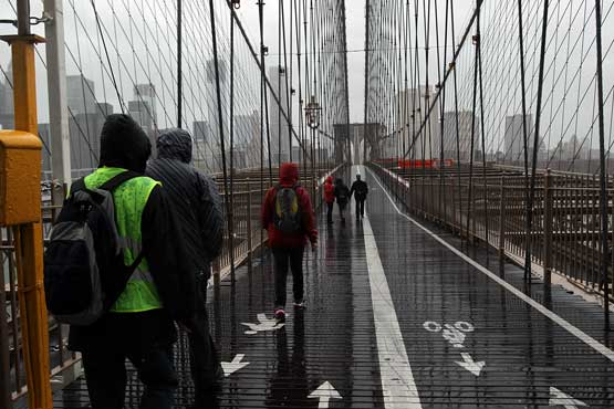 People walk across the Brooklyn Bridge as Hurricane Sandy begins to affect the area on October 29, 2012 in New York City. The storm, which threatens 50 million people in the eastern third of the US, is expected to bring days of rain, high winds and possibly heavy snow. New York Governor Andrew Cuomo announced the closure of all New York City will bus, subway and commuter rail service as of Sunday evening (Getty Images/AFP)
