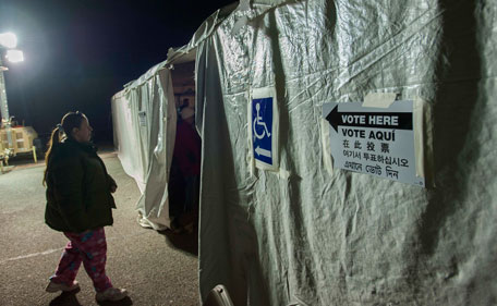A voter makes her way to a poling station, lit by generator light, during the U.S. presidential election in the Staten Island Borough of New York November 6, 2012. The aftermath of Superstorm Sandy created chaos and long lines at voting stations in the U.S. Northeast on Tuesday while officials braced for a new storm due to batter the region on Wednesday. (REUTERS)