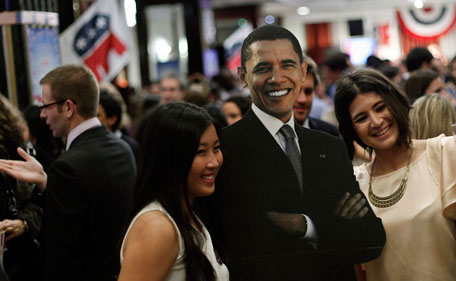 People pose with a picture of President Barack Obama during the Election Night Party 2012 following the U.S. Presidential Election, at the Intercontinental Hotel in Madrid, Spain, Wednesday, Nov. 7, 2012. (AP)