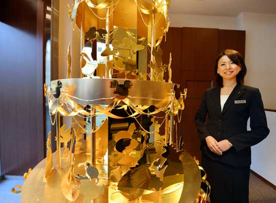 An employee of Japan's jeweler Ginza Tanaka introduces the 350 million yen (4,270,000 USD) Disney Gold Christmas Tree which is 2.4 meters in height and features 50 Disney characters made ofgold, in Tokyo on November 21, 2012. The Christmas tree will be displayed in the shop until 25 December. (AFP)