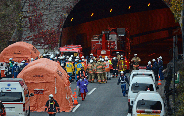 Rescue workers and police gather outside the Sasago tunnel along the Chuo highway near the city of Otsuki in Yamanashi prefecture, 80 kms west of Tokyo on December 2, 2012 after part of the tunnel collapsed. Japanese rescuers found several charred bodies in the highway tunnel that collapsed early in the day, crushing cars and triggering a blaze, and sparking fears of another cave-in. (AFP)