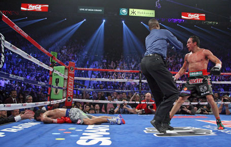 Referee Kenny Bayless holds back Juan Manuel Marquez (right) as Manny Pacquiao lies face down on the mat after being knocked out on December 8, 2012, at the MGM Grand Garden in Las Vegas, Nevada. (AFP)