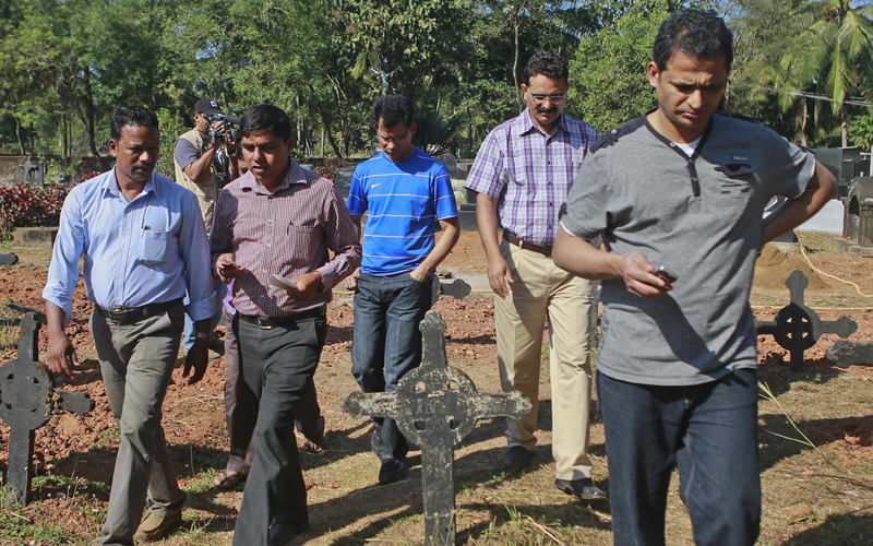 Jacintha Saldanha's widower Ben Barboza (C, in blue) looks at the grave for his wife during preparations for her funeral at a cemetery in Shirva, about 52 km north of Mangalore December 17, 2012. (REUTERS)