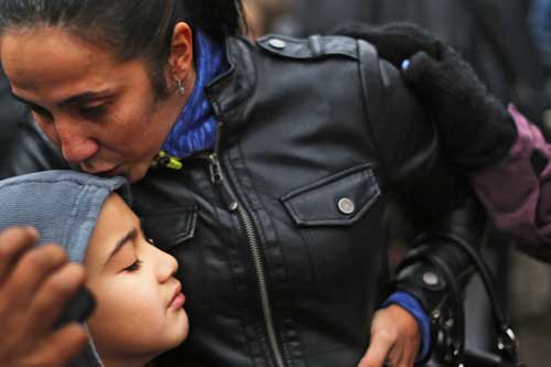 Ty Diaz is kissed by his mother Yvette at a memorial down the street from the Sandy Hook School December 16, 2012 in Newtown, Connecticut. Twenty-six people were shot dead, including twenty children, after Adam Lanza opened fire at Sandy Hook Elementary School. (Spencer Platt/Getty Images/AFP)