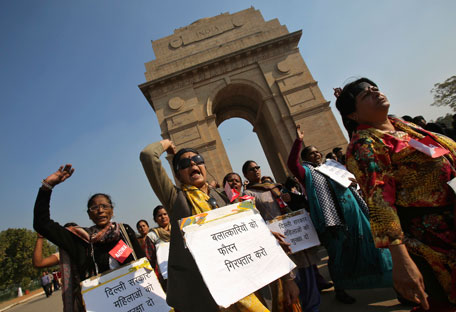 Demonstrators shout slogans as they carry placards in front of the India Gate during a protest rally organised by various women's organisations in New Delhi December 21, 2012. Thousands of protesters took to the streets in various parts of the country to demand urgent action against the men who took turns to rape a 23-year-old woman on a moving bus on December 16, local media reports said. The placards read, "Immediately arrest rapists" (C) and "Delhi Government; Ensure security for women". (REUTERS)