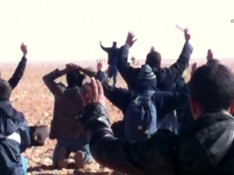 A still image broadcast by Algeria's Ennahar TV on January 19, 2013 shows hostages surrendering to Islamist gunmen who overtook a gas facility in Tiguentourine near In Amenas in the south of the country. Islamists killed all seven of their remaining foreign captives before being gunned down at a gas plant in the Algerian desert, state media said, ending one of the bloodiest international hostage crises in years. (AFP)