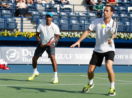 Mchael Llodra returns as partner Mahesh Bhupathi looks on during the final of the Duabi Duty Free Tennis Championship. (SUPPLIED)