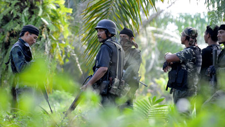 In this picture taken on March 2, 2013, a group of Malaysian police commandos stand guard near the area where the stand-off with Filipino gunmen took place in Tanduo village, Lahad Datu, Sabab , Malaysia. Gunmen ambushed and killed five Malaysian policemen as fears mounted that armed intruders from the southern Philippines had slipped into at least three coastal districts on Borneo island, officials said Sunday. (AP)