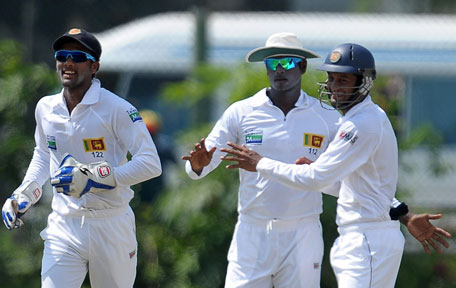 Sri Lankan captain Angelo Mathews (centre) celebrates with teammates Dimuth Karunaratne (right) and wicketkeeper Dinesh Chandimal after he dismissedBangladeshi batsman Mohammad Ashraful during the fourth day of the opening Test match at the Galle International Cricket Stadium in Galle on March 11, 2013. (AFP) PHOTO/LAKRUWAN WANNIARACHCHI