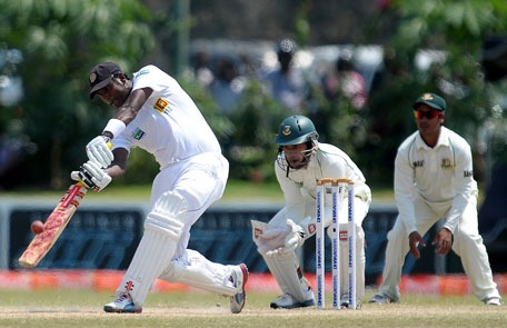 Sri Lankan captain Angelo Mathews (left) plays a shot as Bangladeshi wicketkeeper and captain Mushfiqur Rahim looks on during the final day of the first Test at the Galle International Cricket Stadium in Galle on March 12, 2013. (AFP)