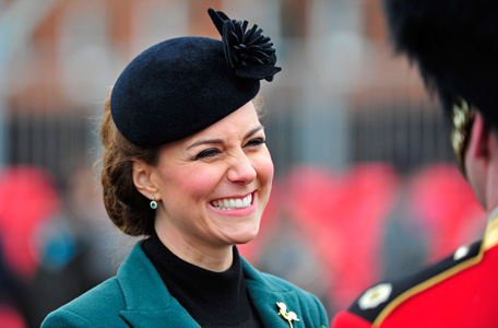 Britain's Catherine, Duchess of Cambridge smiles during a visit with her husband, Prince William, to attend a St Patrick's Day Parade at Mons Barracks in Aldershot, southern England March 17, 2013.  Prince William attended the Parade as Colonel of the Regiment, and the Duchess presented the traditional sprigs of shamrocks to the Officers and Guardsmen of the Regiment. (REUTERS)