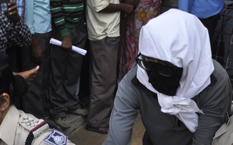 A Swiss woman with her face covered is taken to a hospital by police for her medical examination at Gwalior in the central Indian state of Madhya Pradesh. (REUTERS)
