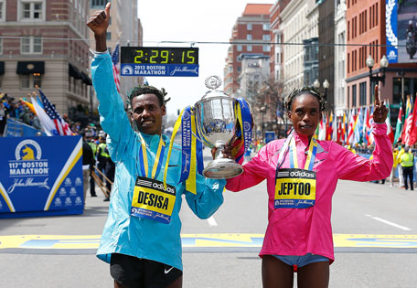 Rita Jeptoo (right) of Kenya, winner of the women's division, and Lelisa Desisa Benti of Ethiopia, winner of the men's division, hold a trophy during post-race activities of the 117th Boston Marathon on April 15, 2013 in Boston, Massachusetts. (GETTY)